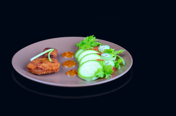 Chicken meat, breaded and fried with fresh vegetables in a sauce