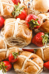 hot cross buns and sweet strawberries on a cake stand