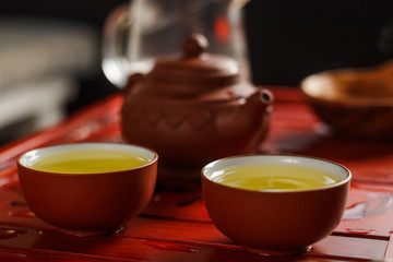 Two bowls with fresh oolong tea on tea desk.