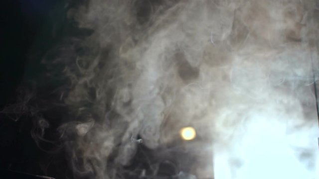 White smoke from a smoke machine in the dark, slow motion.
