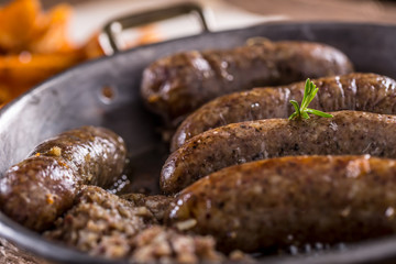 Sausages.Roasted pork sausage in a pan with potatoes and rosemary.