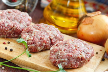 Raw cutlets on a chopping board and ingredients