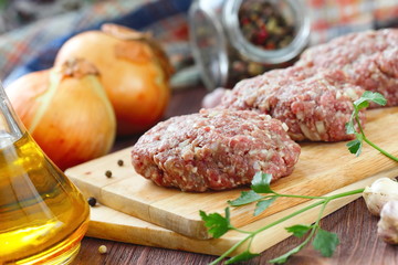 Raw cutlets on a chopping board and ingredients