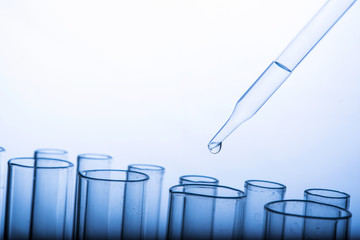 Dropping chemical liquid to test tubes, laboratory research and development concept