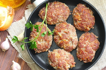 Cutlets with vegetables and herbs in pan