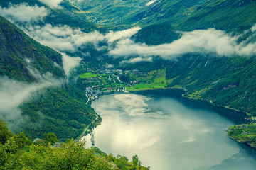 Mountain landscape with cloudy sky. Geiranger fjord in rainy weather. Wild beautiful nature Norway in evening. 
