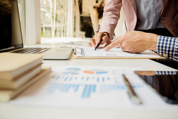 Business concept. Business people discussing the charts and graphs showing the results of their successful teamwork. Selective focus.