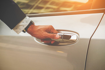 Cropped image of businessman opening door on his car