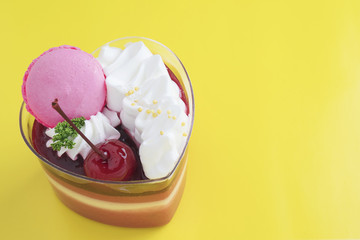 Colorful strawberry cake and macaron on yellow background