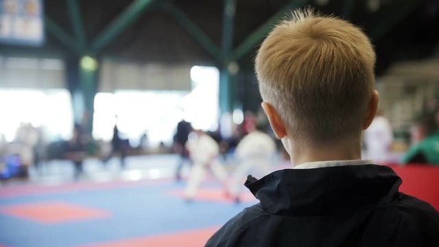 Karate championship - teenager boy looking at karate fighting - spectator at competition