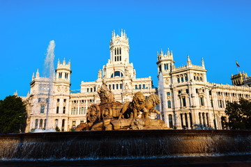 Fototapeta na wymiar Madrid, Spain. Cybele Palace and fountain at the Plaza Cibeles in Madrid, Spain. Famous landmark in the evening with clear blue sky at the background