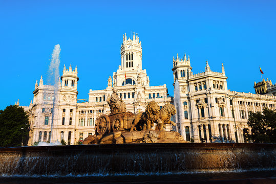 Madrid, Spain. Cybele Palace and fountain at the Plaza Cibeles in Madrid, Spain. Famous landmark in the evening with clear blue sky at the background