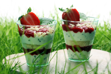 A cup of strawberries and cake with whipped cream