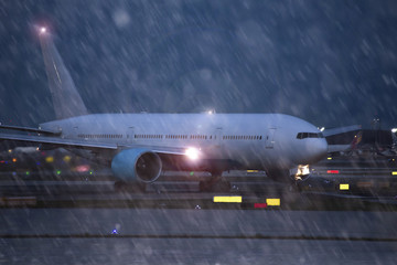 airplane starting at an airport on an rainy evening