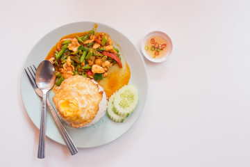 Curry fried rice with chicken and fried egg on white table.