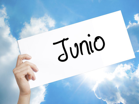 Paper with text Junio (June in Spanish)   . Man Hand Holding Sign on white paper. Isolated on sky background