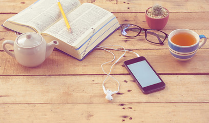 Listening to music on smartphone while drinking hot tea, flat lay and vintage style