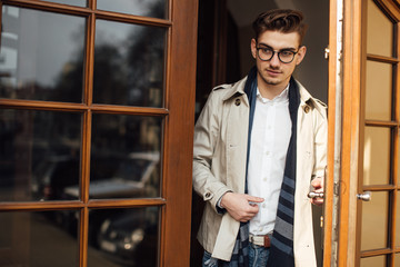 Fashionable man leaving working place, opening doors