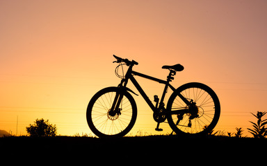 Fototapeta na wymiar silhouette of parked bicycle on warm tone with some copy space