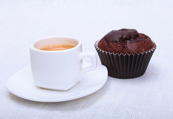 Fresh homemade muffin, cake and white cup of Cappuccino on white background.