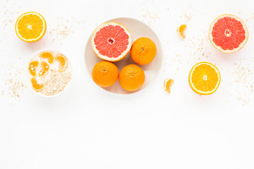 Healthy breakfast with yogurt, colorful fresh citrus fruit, cereal and muesli on white background. Flat lay, top view, mock up.