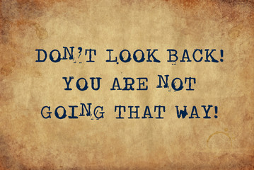 Inspiring motivation quote of don't look back you are not going that way with typewriter text. Distressed Old Paper with Typing image.