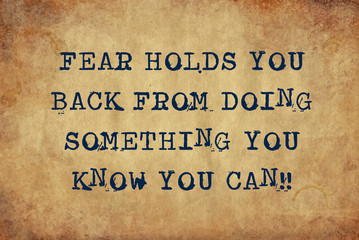 Inspiring motivation quote of fear holds you back from doing something you know you can with typewriter text. Distressed Old Paper with Typing image.