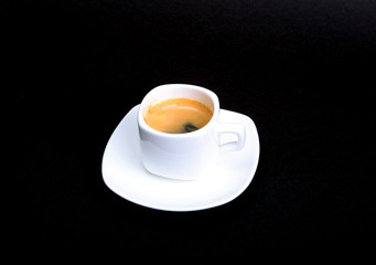 Classic espresso coffee in white cup isolated on dark background. Top View.
