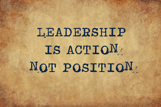 Inspiring motivation quote of leadership is action not position with typewriter text. Distressed Old Paper with Typing image.