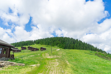 View of a wooden mountain cabin with mountains in the background