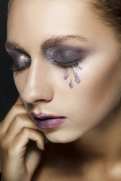 Beauty portrait of a young blond girl with smoky eyes makeup. Art beauty design