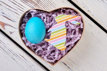 Easter gift box, wood surface. Blue chicken egg.