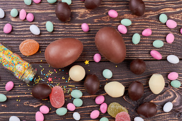 Candies on wood. Chocolate eggs and sprinkle dots. Party sweets ideas.