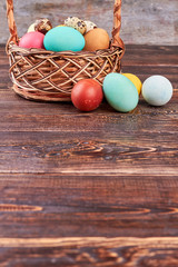 Easter basket, brown wood surface. Wicker basket and dyed eggs. Orthodox Easter traditions.