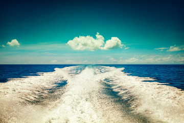 Background water surface behind of fast moving motor boat in vintage retro style. Vintage sky...