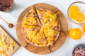 Top view of homemade pizza with yellow tomatoes