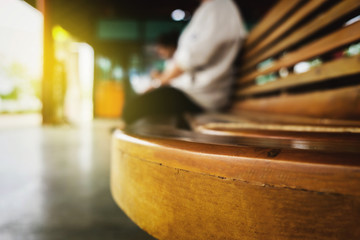 young man sitting waiting for train, blurred background.