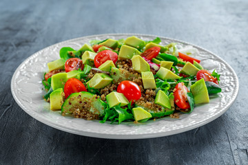 Quinoa tabbouleh salad with avocado, tomatoes, cucumber, green onion. Concept healthy food.