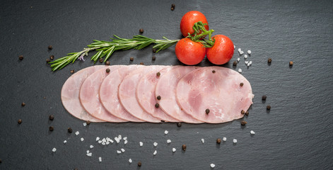 Sliced ham sausage on a stone background