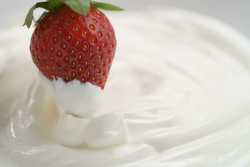 dipping fresh strawberry into cream, delicious food