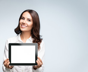 Naklejka premium Businesswoman showing blank tablet pc, on grey
