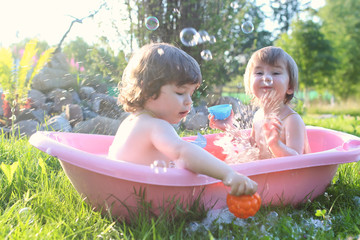 twins boy and girl in bath water outdoor