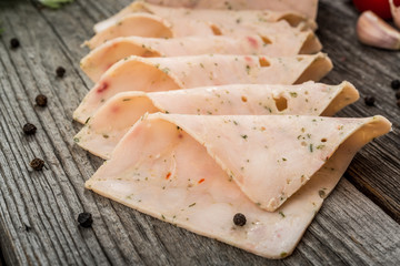 Cut sausage from ham on a wooden background