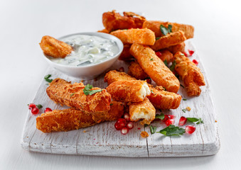 Crispy Halloumi cheese sticks Fries with yogurt for dipping and pomegranate seeds.