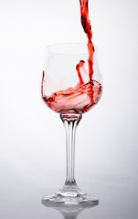 Pour a glass of red wine is. On a white background