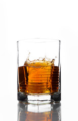 A glass of whiskey in which poured on a white background.