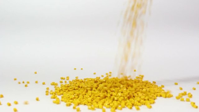 Plastic pellets spilling on white background .Polymeric dye ,a colorant for plastics.