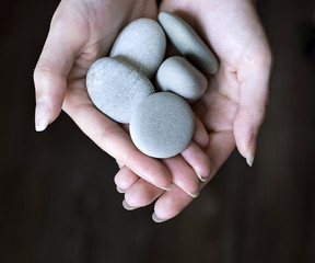 Stones beautifully laid out on the hand - obrazy, fototapety, plakaty