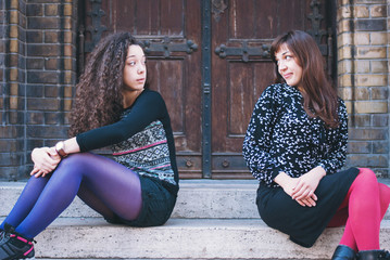 Two teenage girls sit outside and talk, after an argument and discussions. not arguing more and continue to re-socialize