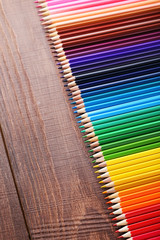 Drawing colourful pencils on brown wooden table